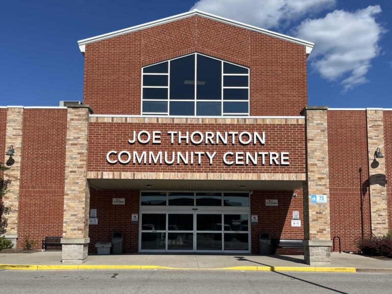 Main entrance of the Joe Thornton Community Centre in St. Thomas, a red-brick recreation complex with the centre name over the doors