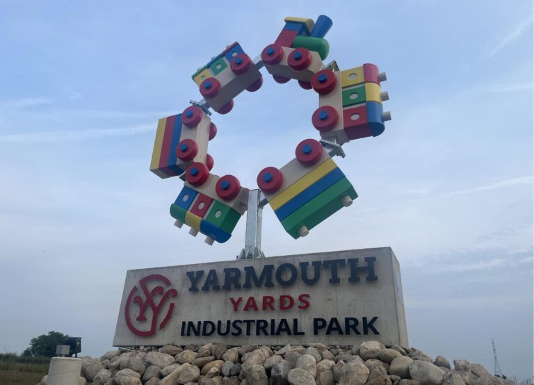 The Imagination Station toy train sculpture above the Yarmouth Yards Industrial Park entrance sign