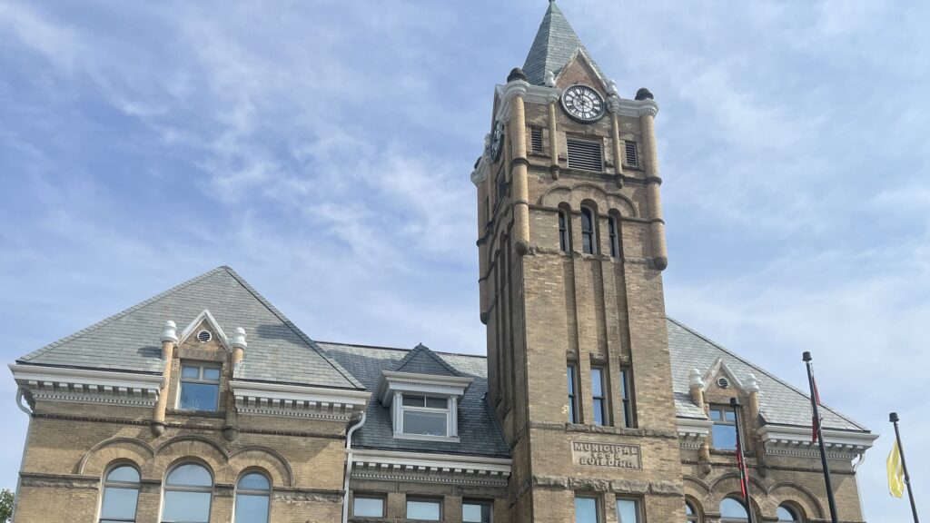 The clock tower and slate roofline of St. Thomas City Hall, with the Municipal Building stone on the tower