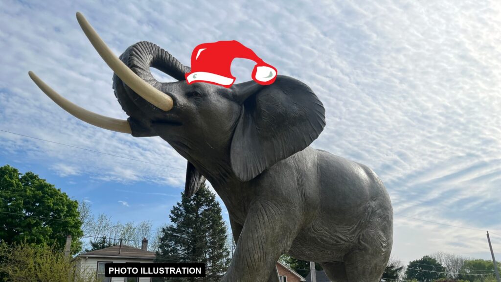 Photo illustration: a cartoon Santa hat added digitally to the Jumbo the Elephant monument in St. Thomas. The hat is not real.